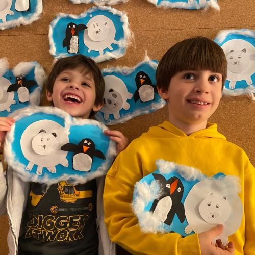Kinder zeigen selbst gemachte Bilder mit Eisbären und Pinguinen